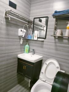 uma casa de banho com um WC, um lavatório e um espelho. em Nanjing Tulou Qingdelou Inn em Nanjing