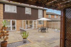 a patio with tables and chairs and a building at Spacious 5 bed Sunninghill with driveway parking in Ascot