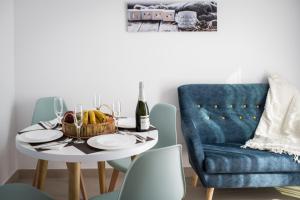 a dining room with a table and a blue chair at MAR BIANCO - Gay Men Only in Maspalomas