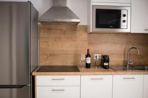 a kitchen with a counter with wine glasses and a sink at MAR BIANCO - Gay Men Only in Maspalomas +43 photos