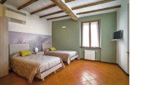 Cette chambre comprend 2 lits et une télévision. dans l'établissement Villaggio Della Salute Più, à Monterenzio