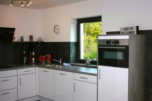 a kitchen with white cabinets and a window at Die Idyllische - Ferienwohnung mit Garten und Sauna in Kleve