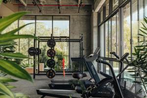 un gimnasio con varias bicicletas estáticas en una sala con ventanas en Wake - branded residences, en Medellín