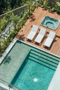 an overhead view of a swimming pool on a deck with lounge chairs at Wake - branded residences in Medellín