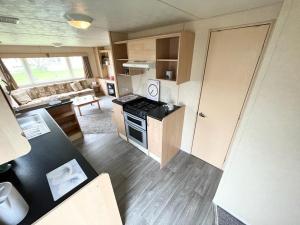 a kitchen and living room with a stove top oven at 8 Berth Holiday Home with Pools on Martello Beach in Jaywick Sands