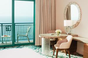 Atlantis, The Palm في دبي: غرفة مع شرفة مع طاولة وكراسي