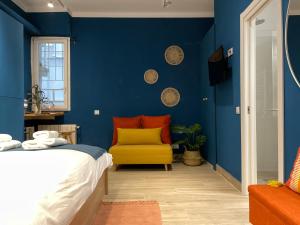 niebieska sypialnia z łóżkiem i żółtym krzesłem w obiekcie Apartamento Opera Suite AIDA Madrid Palacio Real w Madrycie