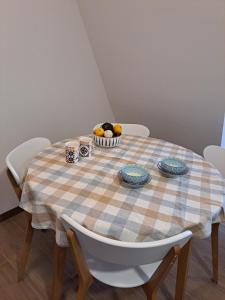 - une table avec un chiffon de table à damer et un bol de fruits dans l'établissement Divcibor 23, à Divčibare