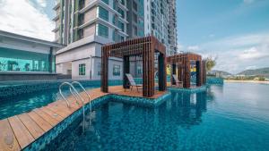 een zwembad naast een groot gebouw met water bij DIY Studio Apartment at Imperium Residence Kuantan in Kampong Seberang Panchor