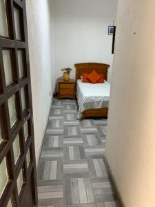 um quarto com uma cama e piso em madeira em Habitación privada peña em Querétaro