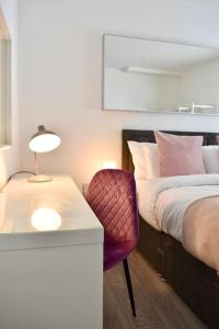 a bedroom with a bed and a table and a chair at The Copperfield Apartment - Broadstairs Central - By Goldex Coastal Breaks in Kent