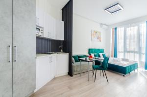 a kitchen and a living room with a table and chairs at Smart App near Railway Station Kvartet 3C in Kyiv