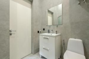 uma casa de banho com um WC, um lavatório e um espelho. em Smart App near Railway Station Kvartet 3C em Kiev
