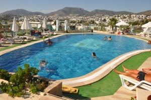 a large swimming pool with people in a resort at Siesta Beach Apartment in Gümbet