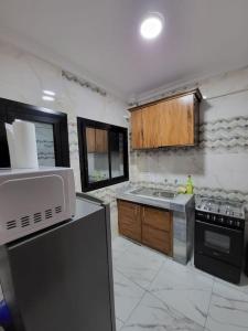 a kitchen with a sink and a stove at Bel appartement neuf et meublé avec parking gratuit in Douala +2 photos
