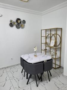 a white room with a table and a shelf at Bel appartement neuf et meublé avec parking gratuit in Douala