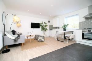 a kitchen and living room with a couch and a table at Long stay offer - Stylish 1 bed flat with parking in Bristol