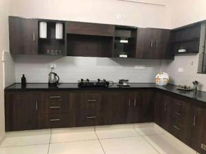 a kitchen with wooden cabinets and black counter tops at Urbane Cove in Trivandrum