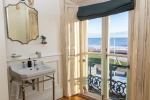 a bathroom with a sink and a view of the ocean at The Palm in Bray