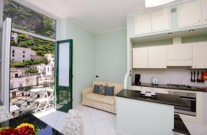 a kitchen and living room with a large window at Lae Domus in Atrani