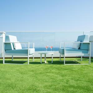 two chairs and a table on a lawn with a view at Hotel Lloret Santa Rosa by Pierre & Vacances in Lloret de Mar