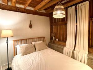 a bedroom with a white bed and a chandelier at Beautifully restored five bedroom historic barn in Oakwood