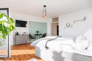 Habitación blanca con cama y escritorio en GREAT CITY VIEW I 26 FLOOR I NETFLIX and BOXSPRINGBED, en Augsburg