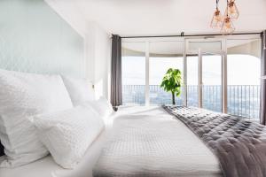 1 dormitorio con cama blanca y ventana grande en GREAT CITY VIEW I 26 FLOOR I NETFLIX and BOXSPRINGBED, en Augsburg