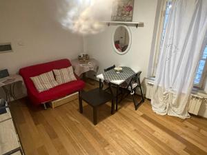 un soggiorno con tavolo e sedia rossa di Incantevole Monolocale a Lucca nel Centro Storico - EstateGuard Group a Lucca