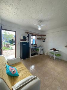 a living room with a couch and a kitchen at POUSADA MORADAS DO JAU in Hermenegildo