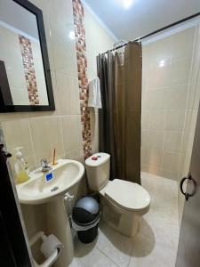 a bathroom with a toilet and a sink and a shower at Casa rústica con terraza, en el corazón del pueblo in San Vicente de Chucurí