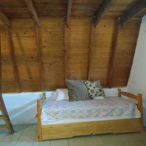 a bed in a room with a wooden wall at Per a Tu in Punta del Este
