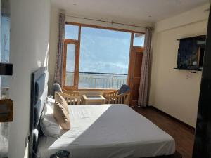 a bedroom with a bed and a large window at Nomad Bed & Breakfast in Manāli