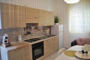 una cucina con armadi in legno e piano cottura. di Casa sul mare a Torre Canne