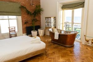 a bedroom with a bath tub and a bed at The Palm in Bray