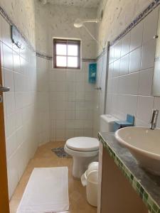 a bathroom with a toilet and a sink at POUSADA MORADAS DO JAU in Hermenegildo +33 photos