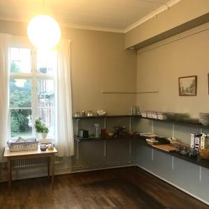 a kitchen with shelves and a window and a table at Ronneby Brunnspark Vandrarhem och B&B in Ronneby
