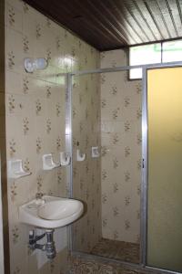 een badkamer met een wastafel en een douche bij Hipilandia Amazonas Hostel in Leticia