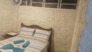 a small bedroom with a bed with towels on it at 746 Pousada in Nova Friburgo