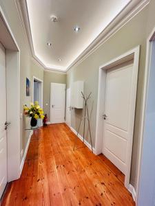 a hallway with a hard wood floor and white doors at Blue City Apartment’s in Hamburg