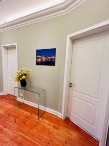 a room with a door and a vase of flowers on a table at Blue City Apartment’s in Hamburg