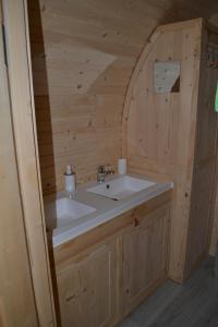 baño con lavabo en una cabaña de madera en LA ROULOTTE VITICOLE, en Cauro
