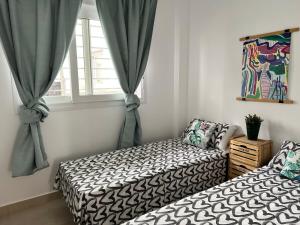 um quarto com 2 camas e uma janela em Bnbook Medea Apartments 2 em Fuengirola