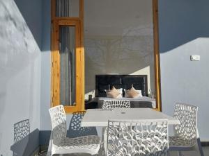 a table and chairs on a balcony with a bed at Nomad Bed & Breakfast in Manāli