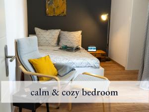 a small bedroom with a bed and a chair at Parterre Lounge mit Terrasse -Nähe Karlsruhe & KIT - ohne Treppen -barrierefreie Dusche in Linkenheim-Hochstetten