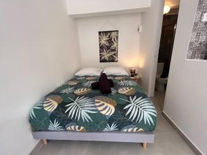 a bed in a small room with a large bed sidx sidx at Studio jungle chic in Le Tampon