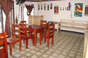 a dining room with a wooden table and chairs at Hipilandia Amazonas Hostel in Leticia