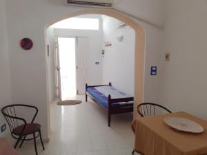 a room with a bed and a table and chairs at Djerba house in Houmt Souk