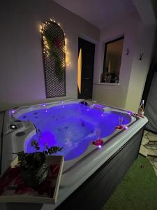 a large blue tub with lights in a bathroom at Chambre au calme avec spa privatif gratuit sud aveyron les palmiers des causses in Saint-Rome-de-Tarn