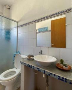 a bathroom with a sink and a toilet and a mirror at POUSADA MORADAS DO JAU in Hermenegildo